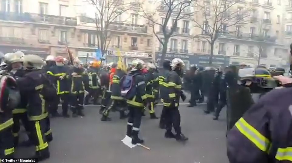 23989862 7938937 Firefighters can be seen clashing with police officers in Paris a 19 1580235649283