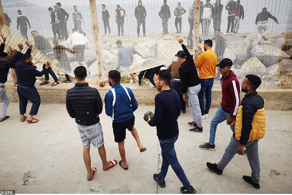 Spain Deploys Army to AID TENS OF THOUSANDS of Moroccans and Africans to Invade their Country 9 43125121 9591093 Pictured Moroccan nationals break the fence on the Moroccan side a 452 1621343366119