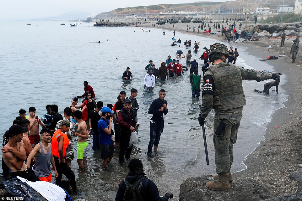 Spain Deploys Army to AID TENS OF THOUSANDS of Moroccans and Africans to Invade their Country 3 43133641 9591093 A Spanish legionnaire indicates the direction to follow to Moroc a 466 1621343366129